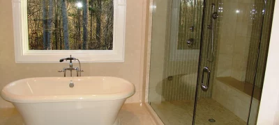 A modern bathroom with a soaking tub, a walk-in shower, and plenty of natural light from a wide window near the bathtub.